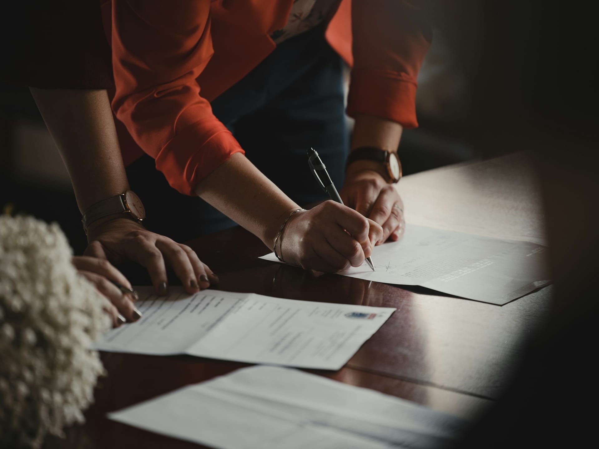 Two people reviewing a printed contract together at a desk
