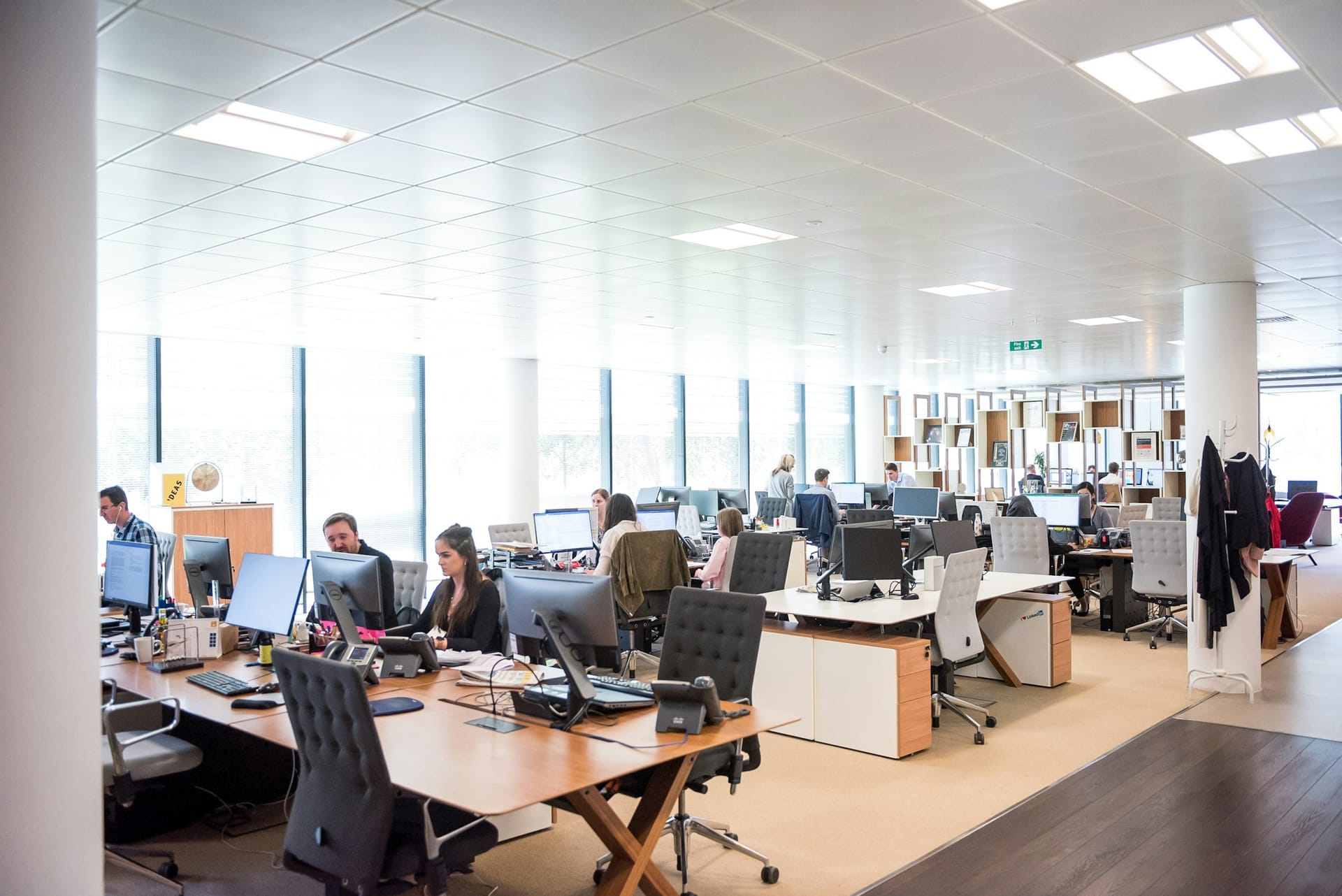 A recruitment professional working at a desk in an open-plan office